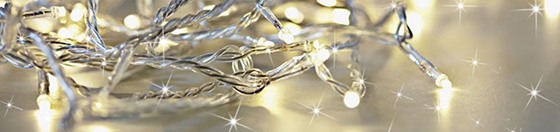 A close-up of a string of fairy lights on a silver surface.