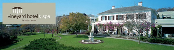 A grand old-fashioned house and established gardens, with the Vineyard Hotel & Spa logo superimposed on the corner.