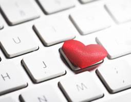 A close up of a keyboard with a red heart on one key.