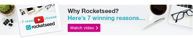 A Rocketseed email banner with the message "Why Rocketseed? Here's 7 winning reasons..." above a Watch video button, on a bird's-eye-view photograph of a desk with various tech and stationary on it.