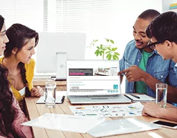 A man points to a laptop screen showing the Rocketseed email banner and signature; a man and two women look at it.