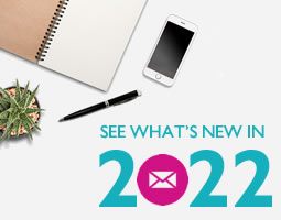 A birds-eye-view of a desk with a plant, open notebook and pen, with the words "SEE WHAT'S NEW IN 2022".