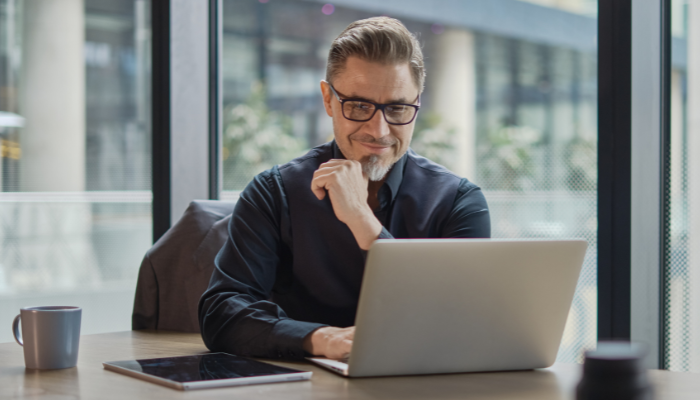 A professional man working on a laptop in modern office setting