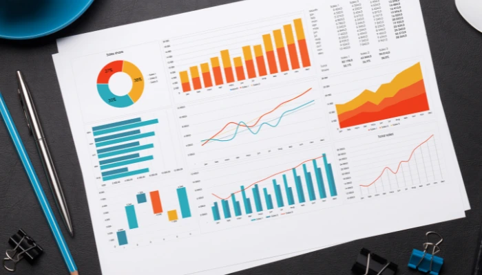 Pieces of paper on a desk showing statistics and graphs.